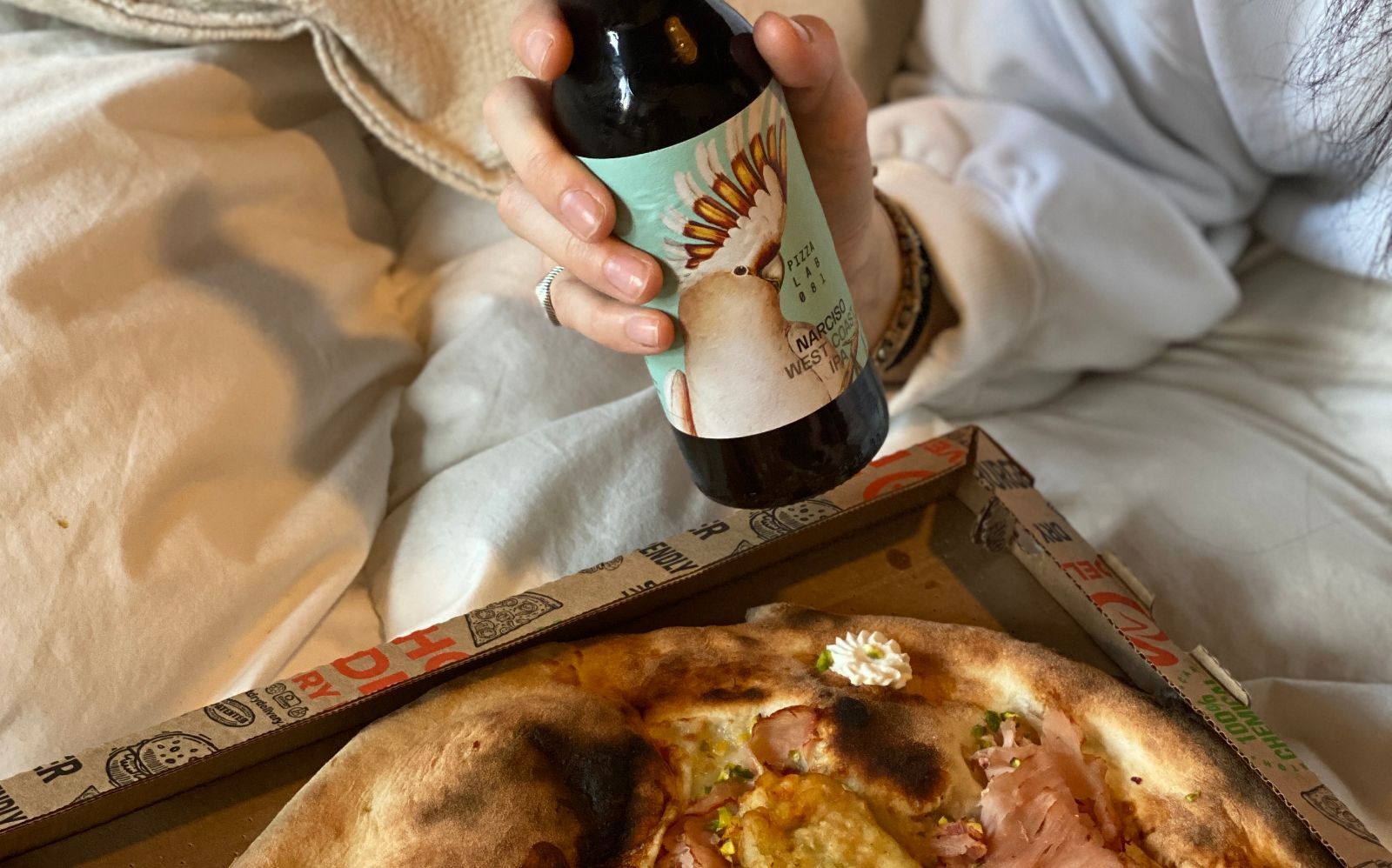 Birra e pizza su un letto